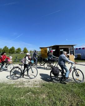 Fahrradfahrer*innen radeln am Energiemobil vorbei.